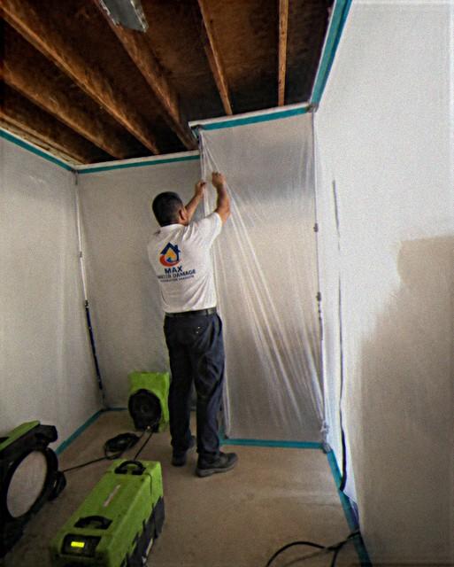 Max technician sealing plastic containment around a work area