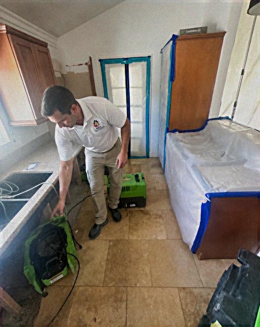 Max technician running an air mover on a water damaged floor